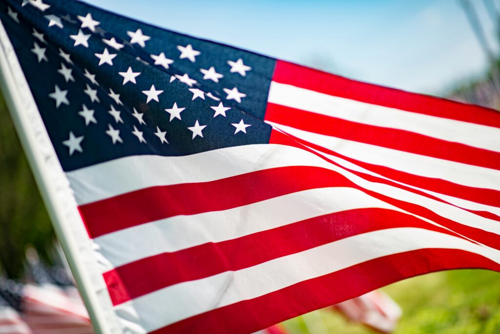Close-up of the American flag waving in the summer breeze, symbolizing freedom and patriotism.